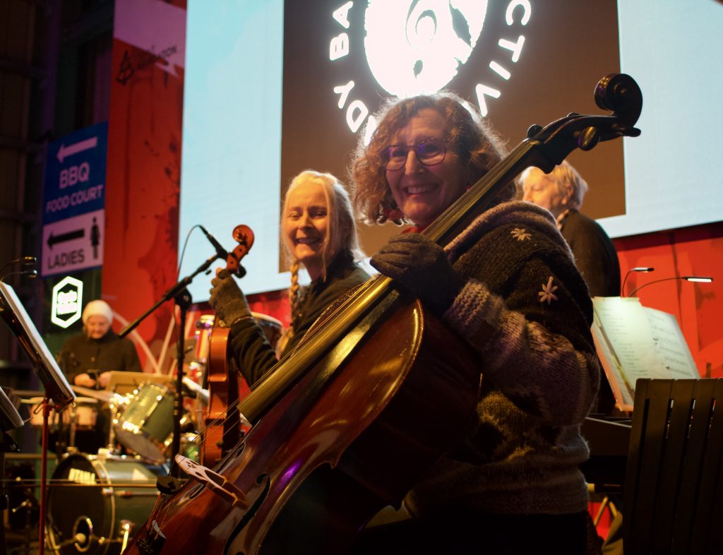 Two players of stringed instruments looking at camera