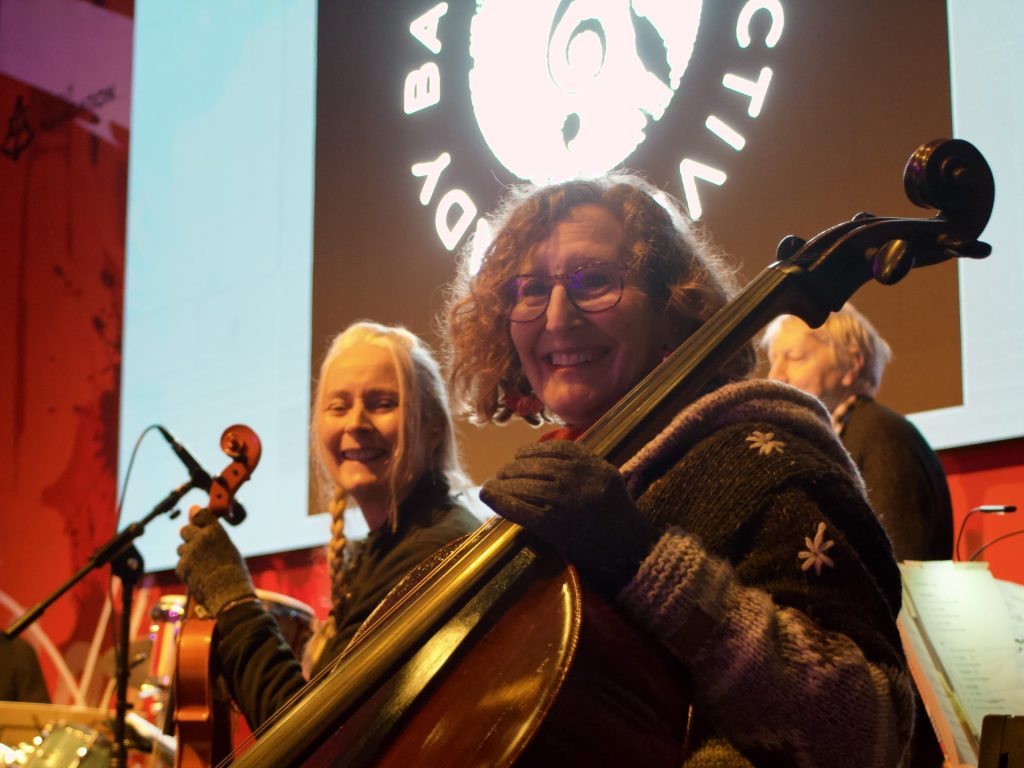 Two players of stringed instruments looking at camera