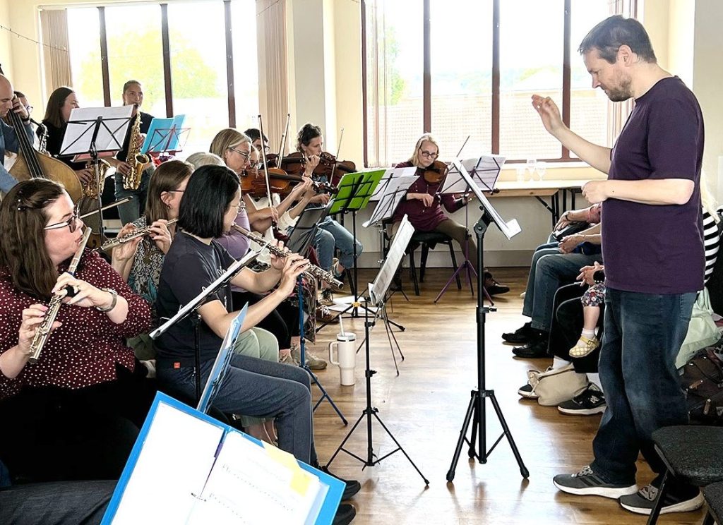 Lady Bay Music Ensemble with flute players in the foreground and conductor in middle ground