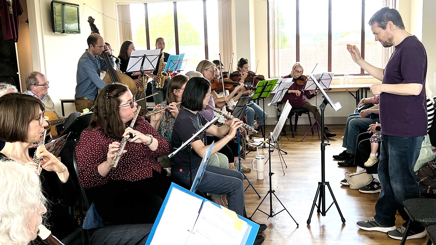 Lady Bay Music Ensemble with flute players in the foreground and conductor in middle ground